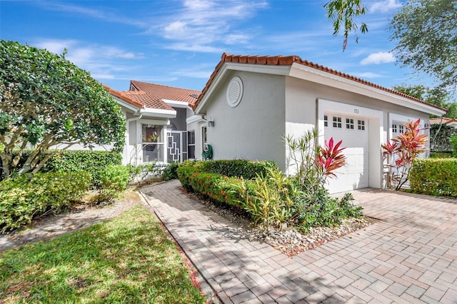 7713 Springwater Pl, Boynton Beach, FL 33437 - view of front of property featuring a garage, a tile roof, stucco siding, and decorative driveway