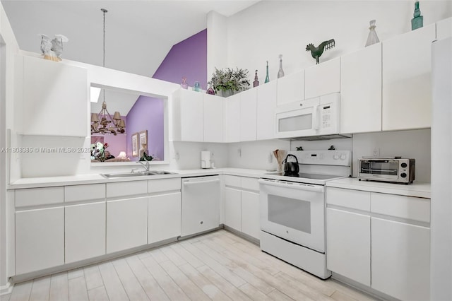 7713 Springwater Pl, Boynton Beach, FL 33437 - kitchen featuring white appliances, a sink, vaulted ceiling, light countertops, and a chandelier