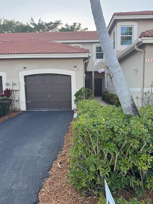 1051 Sorrento Dr, Weston, FL 33326 - view of front facade with asphalt driveway, stucco siding, an attached garage, and a tile roof