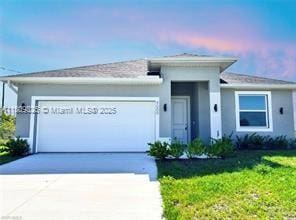 9009 N Indio Cir, La Belle, FL 33935 - view of front of house with driveway, an attached garage, a front yard, and stucco siding