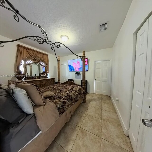10341 SW 179th St, Miami, FL 33157 - bedroom with light tile patterned flooring, a textured ceiling, and baseboards