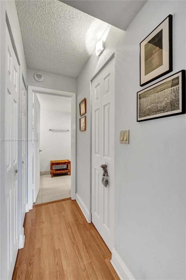 1201 S Ocean Dr Unit 609S, Hollywood, FL 33019 - hall with light wood-style floors, baseboards, and a textured ceiling