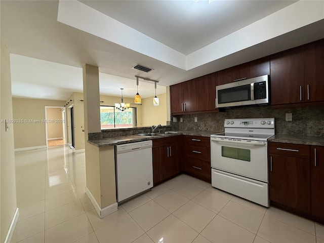 9255 SW 125th Ave Unit 304R, Miami, FL 33186 - kitchen with white appliances, dark countertops, decorative backsplash, light tile patterned floors, and a chandelier