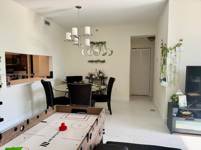 9725 NW 52nd St Unit 421, Doral, FL 33178 - dining space with light marble finish floors, a chandelier, and baseboards