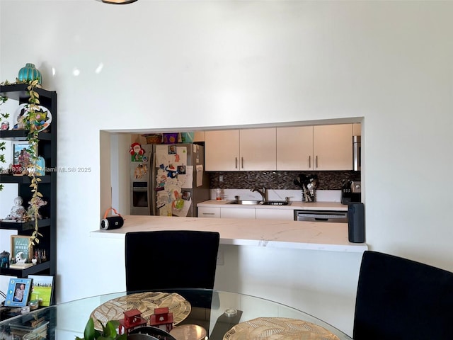 9725 NW 52nd St Unit 421, Doral, FL 33178 - kitchen featuring stainless steel fridge, a sink, backsplash, light stone counters, and cream cabinetry