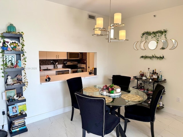 9725 NW 52nd St Unit 421, Doral, FL 33178 - dining room with light marble finish flooring, baseboards, and a chandelier