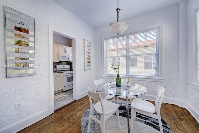 900 16th St Unit 204, Miami Beach, FL 33139 - dining area with a textured wall, dark wood-style floors, and baseboards
