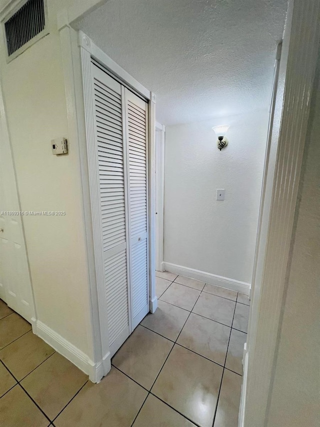 606 W 81st St Unit 224, Hialeah, FL 33014 - hall featuring light tile patterned floors, baseboards, and a textured ceiling