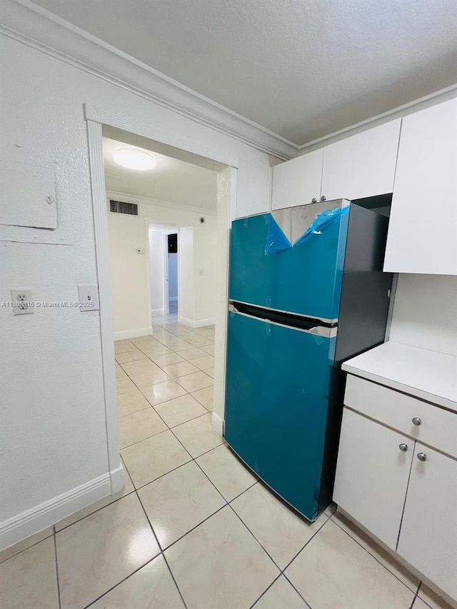 606 W 81st St Unit 224, Hialeah, FL 33014 - kitchen with freestanding refrigerator, ornamental molding, white cabinets, light countertops, and light tile patterned floors