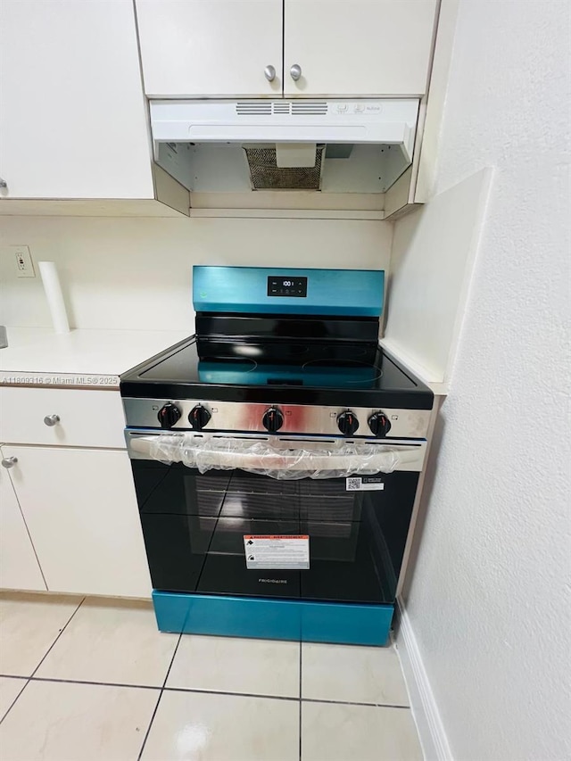 606 W 81st St Unit 224, Hialeah, FL 33014 - kitchen featuring stainless steel electric range oven, under cabinet range hood, white cabinets, light countertops, and light tile patterned floors