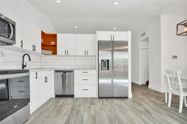 6933 SW 152nd Ct, Miami, FL 33193 - kitchen featuring stainless steel appliances, open shelves, light wood-style flooring, recessed lighting, and tasteful backsplash