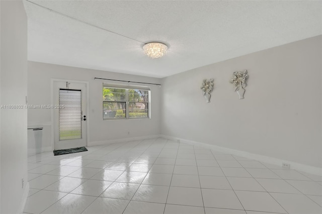 481 Durham Q Unit 481, Deerfield Beach, FL 33442 - spare room featuring light tile patterned flooring, a chandelier, and a textured ceiling