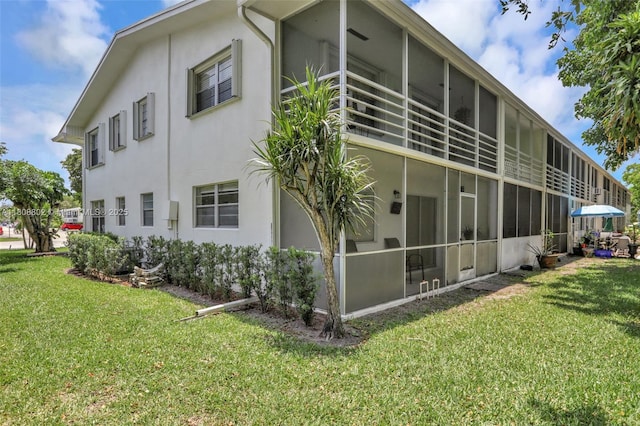 481 Durham Q Unit 481, Deerfield Beach, FL 33442 - back of house with a sunroom, stucco siding, and a yard