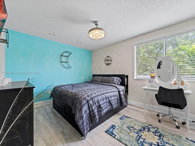 14474 SW 144th Ter, Miami, FL 33186 - bedroom with wood finished floors, a textured ceiling, baseboards, and an office area