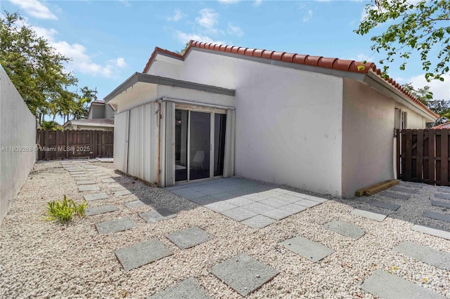 11250 SW 157th Ct, Miami, FL 33196 - rear view of property featuring a fenced backyard, stucco siding, a tile roof, and a patio area