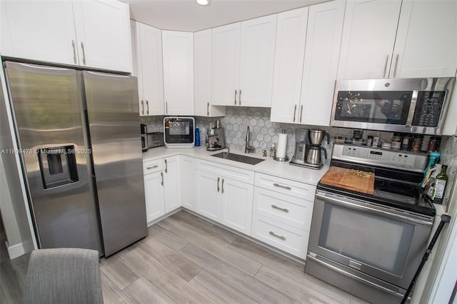 9301 SW 37th St, Miami, FL 33165 - kitchen featuring appliances with stainless steel finishes, a sink, light countertops, tasteful backsplash, and white cabinets