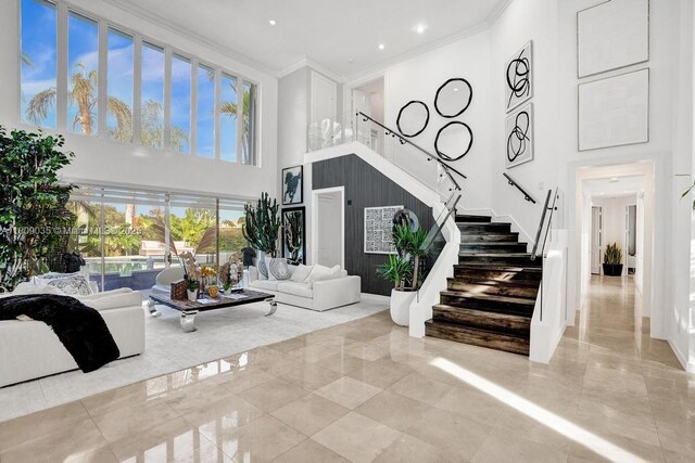 8580 Egret Lakes Ln, West Palm Beach, FL 33412 - living room featuring a towering ceiling, stairway, ornamental molding, and recessed lighting