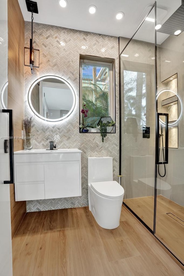 8580 Egret Lakes Ln, West Palm Beach, FL 33412 - bathroom featuring tiled shower, vanity, tile walls, wood finished floors, and recessed lighting