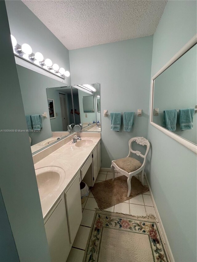1480 Sheridan St Unit 17B, Hollywood, FL 33020 - bathroom featuring a textured ceiling, tile patterned floors, and double vanity