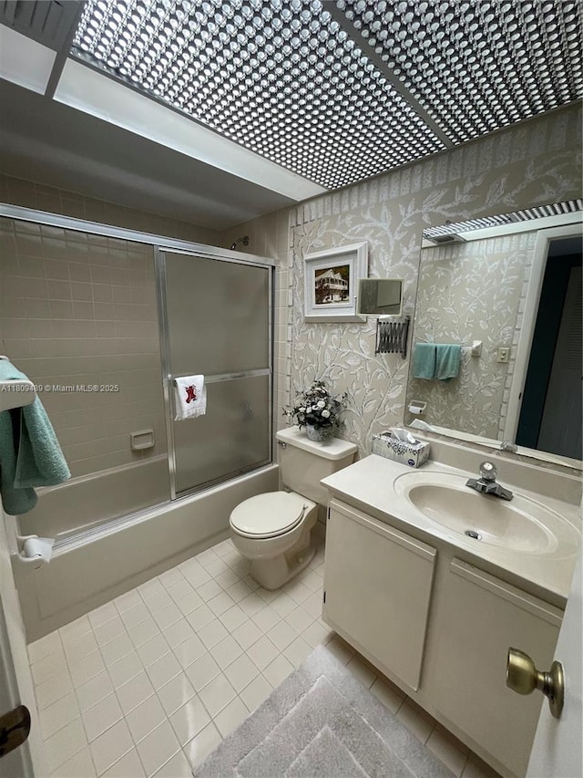 1480 Sheridan St Unit 17B, Hollywood, FL 33020 - bathroom featuring tile patterned flooring, shower / bath combination with glass door, vanity, wallpapered walls, and toilet