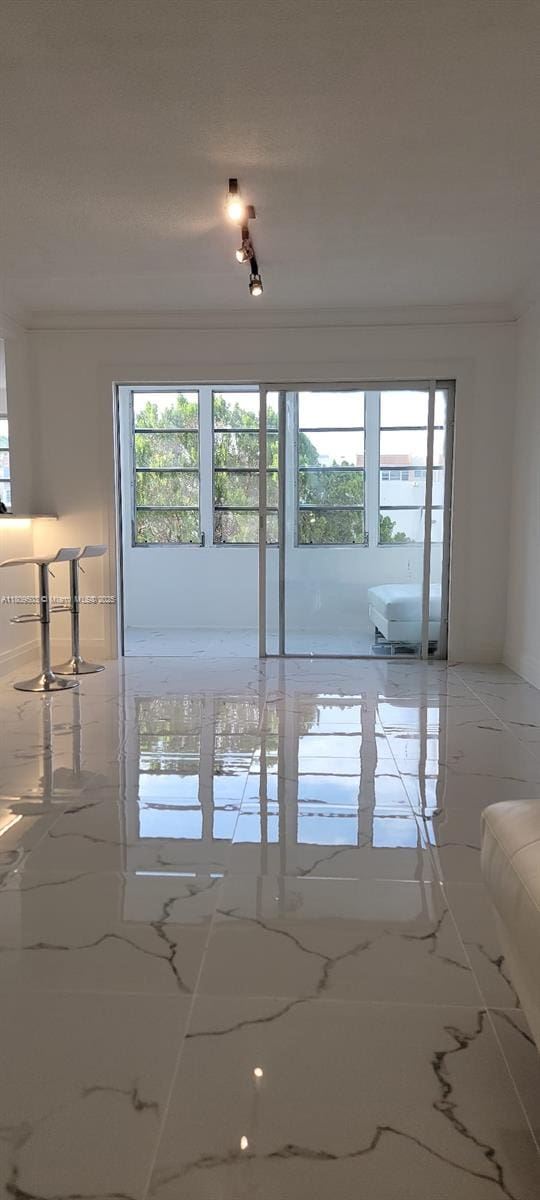 2301 NW 41st Ave Unit 209, Lauderhill, FL 33313 - unfurnished room with healthy amount of natural light, light marble finish flooring, and ornamental molding