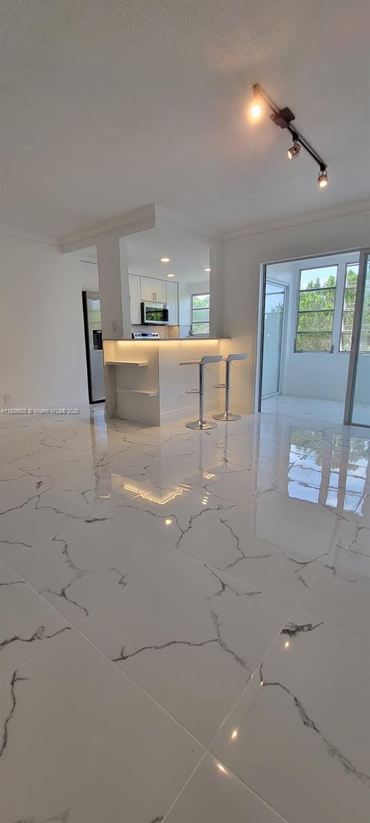 2301 NW 41st Ave Unit 209, Lauderhill, FL 33313 - living area with a textured ceiling and crown molding