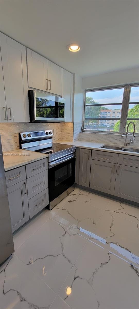 2301 NW 41st Ave Unit 209, Lauderhill, FL 33313 - kitchen featuring stainless steel appliances, a sink, gray cabinetry, backsplash, and recessed lighting