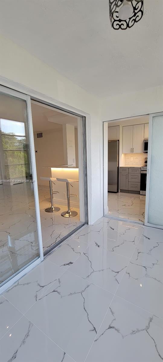 2301 NW 41st Ave Unit 209, Lauderhill, FL 33313 - interior space featuring freestanding refrigerator and light marble finish floors