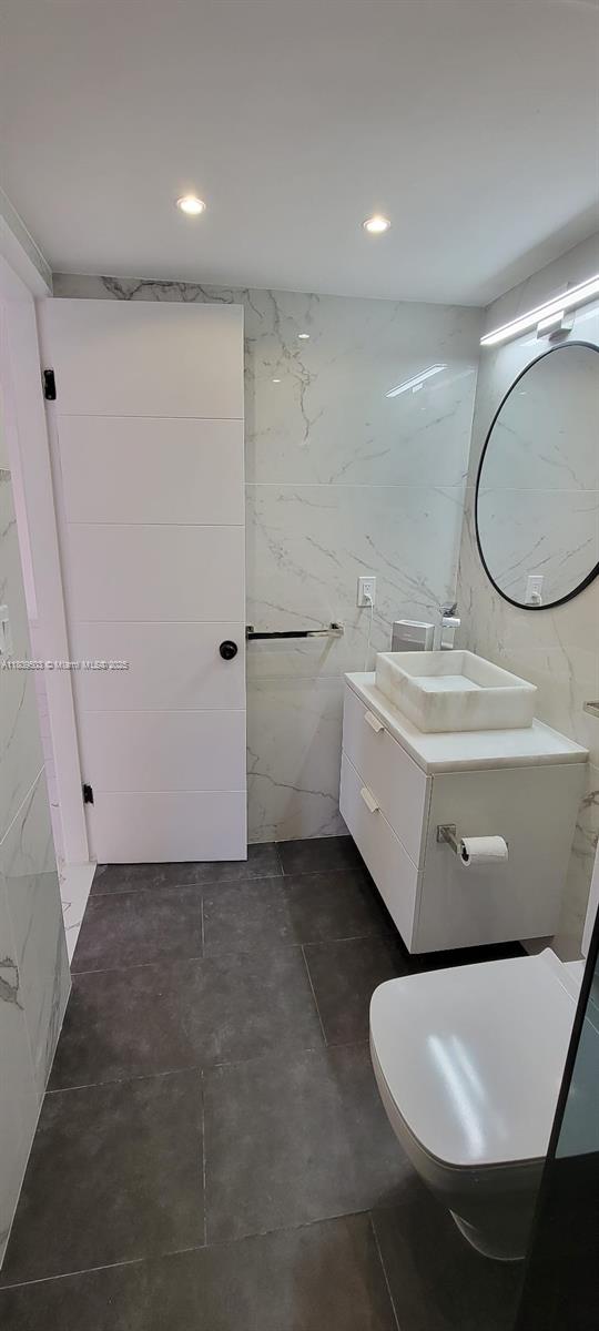 2301 NW 41st Ave Unit 209, Lauderhill, FL 33313 - bathroom with tile walls, vanity, toilet, and recessed lighting