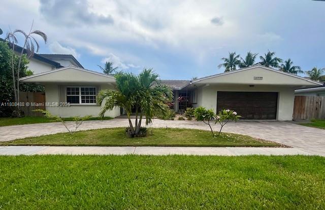 13090 Biscayne Bay Ter, North Miami, FL 33181 - ranch-style house featuring curved driveway, stucco siding, and a garage