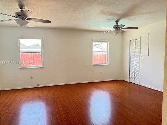 6561 W 13th Ct, Hialeah, FL 33012 - unfurnished room with a ceiling fan, wood finished floors, baseboards, and a textured ceiling