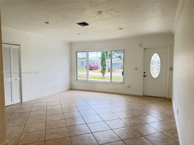 6561 W 13th Ct, Hialeah, FL 33012 - foyer entrance featuring crown molding, light tile patterned floors, and baseboards