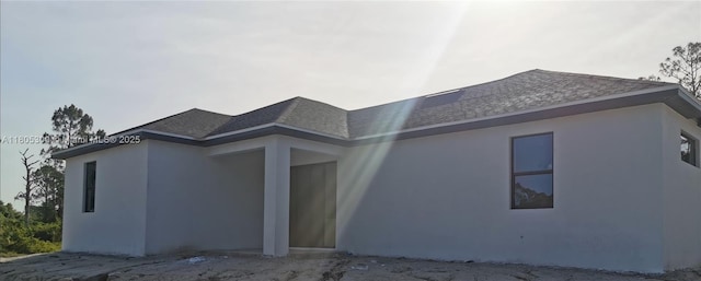 326 Nathan Ave, Lehigh Acres, FL 33974 - back of property featuring roof with shingles and stucco siding