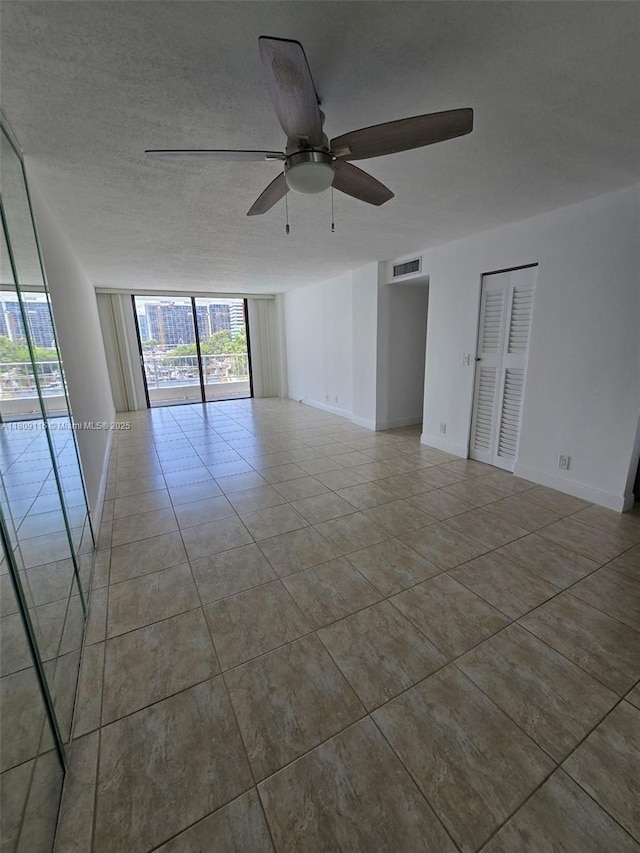 200 SE 15th Rd Unit 6B, Miami, FL 33129 - tiled empty room with ceiling fan, a wall of windows, and baseboards