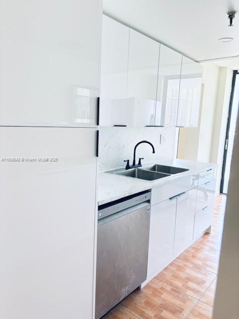 210 174th St Unit 818, Sunny Isles Beach, FL 33160 - kitchen featuring dishwasher, a sink, white cabinetry, light countertops, and light wood-style flooring