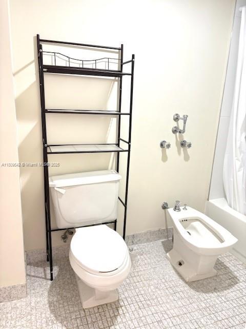 210 174th St Unit 818, Sunny Isles Beach, FL 33160 - bathroom featuring toilet, shower / bathtub combination with curtain, a bidet, and tile patterned flooring