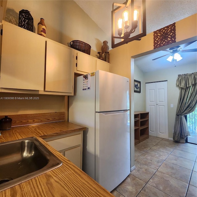5542 Courtyard Dr Unit 5542, Margate, FL 33063 - kitchen featuring freestanding refrigerator, a ceiling fan, white cabinetry, light tile patterned floors, and lofted ceiling