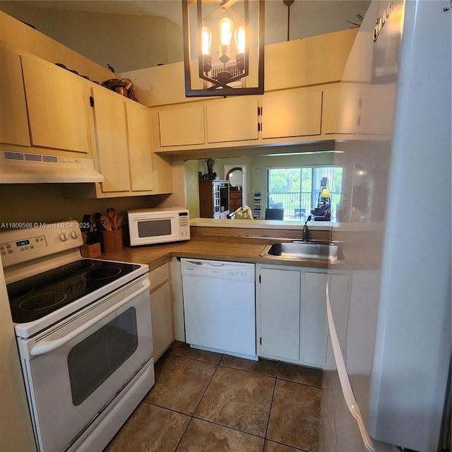 5542 Courtyard Dr Unit 5542, Margate, FL 33063 - kitchen featuring white appliances, under cabinet range hood, dark tile patterned flooring, and white cabinets