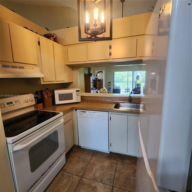 5542 Courtyard Dr Unit 5542, Margate, FL 33063 - kitchen featuring white appliances, under cabinet range hood, dark tile patterned flooring, and white cabinets