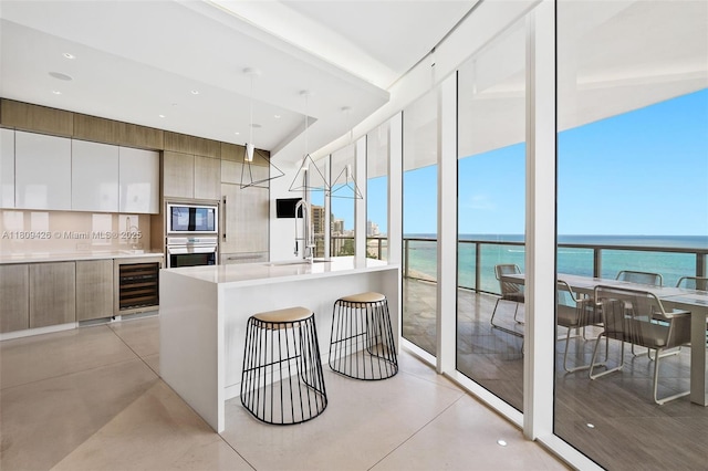 9703 Collins Ave Unit 1700, Bal Harbour, FL 33154 - kitchen featuring stainless steel oven, built in microwave, modern cabinets, wine cooler, and light countertops
