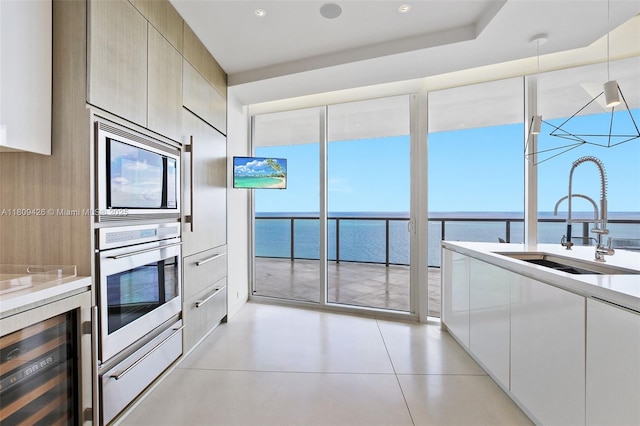 9703 Collins Ave Unit 1700, Bal Harbour, FL 33154 - kitchen with beverage cooler, stainless steel appliances, a sink, modern cabinets, and light countertops