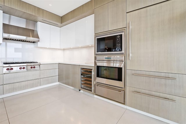9703 Collins Ave Unit 1700, Bal Harbour, FL 33154 - kitchen featuring stainless steel appliances, wine cooler, a warming drawer, wall chimney range hood, and light countertops