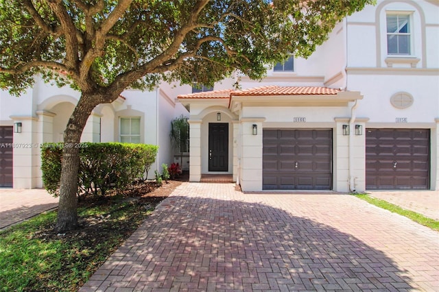 8144 NW 107th Path, Doral, FL 33178 - mediterranean / spanish-style house with stucco siding, decorative driveway, a tile roof, and a garage