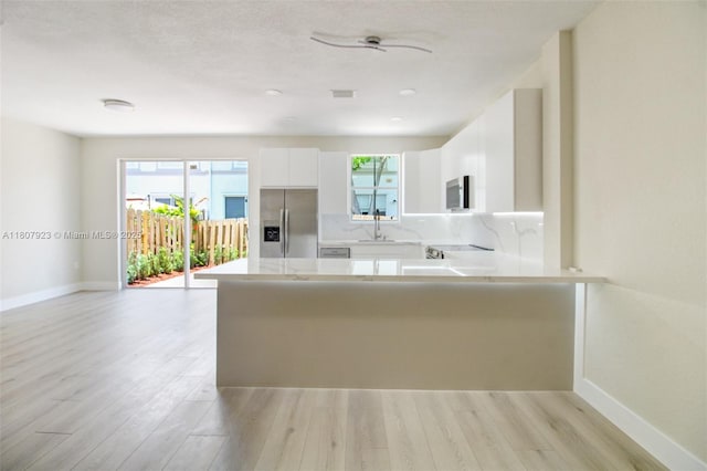 8144 NW 107th Path, Doral, FL 33178 - kitchen featuring appliances with stainless steel finishes, light countertops, baseboards, and a peninsula