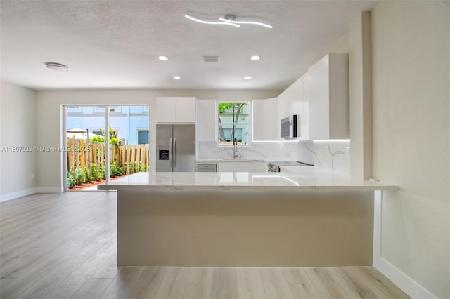 8144 NW 107th Path, Doral, FL 33178 - kitchen with appliances with stainless steel finishes, baseboards, light countertops, a peninsula, and white cabinets