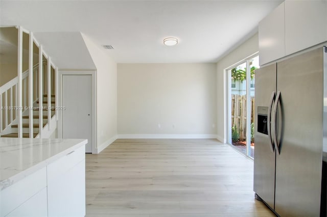 8144 NW 107th Path, Doral, FL 33178 - kitchen featuring stainless steel refrigerator with ice dispenser, light wood-style flooring, white cabinets, and light stone countertops