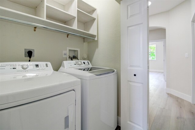 8144 NW 107th Path, Doral, FL 33178 - washroom with separate washer and dryer, light wood-style flooring, arched walkways, and baseboards