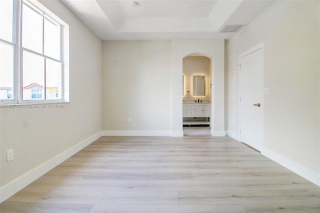 8144 NW 107th Path, Doral, FL 33178 - unfurnished room with arched walkways, a tray ceiling, light wood-style floors, and baseboards