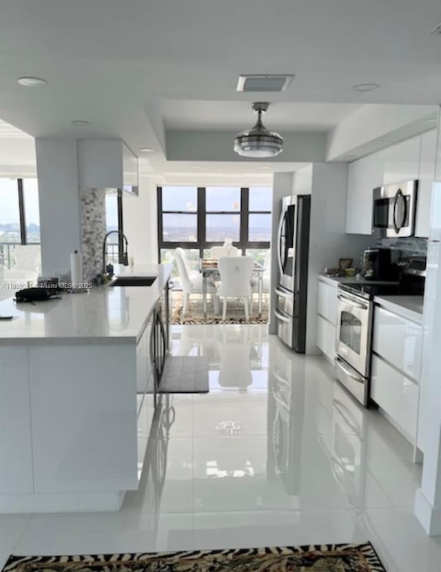 2017 S Ocean Dr Unit 1510, Hallandale Beach, FL 33009 - kitchen featuring a sink, appliances with stainless steel finishes, plenty of natural light, white cabinetry, and a wall of windows