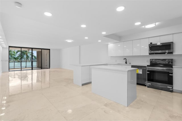 2300 Diana Dr Unit 302, Hallandale Beach, FL 33009 - kitchen featuring stainless steel appliances, modern cabinets, expansive windows, white cabinetry, and light countertops